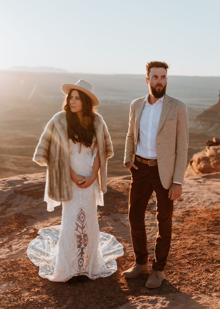 couple posing on canyon overlook at sunset