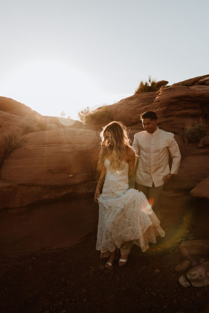 couple walking along rocky path during sunset in Moab