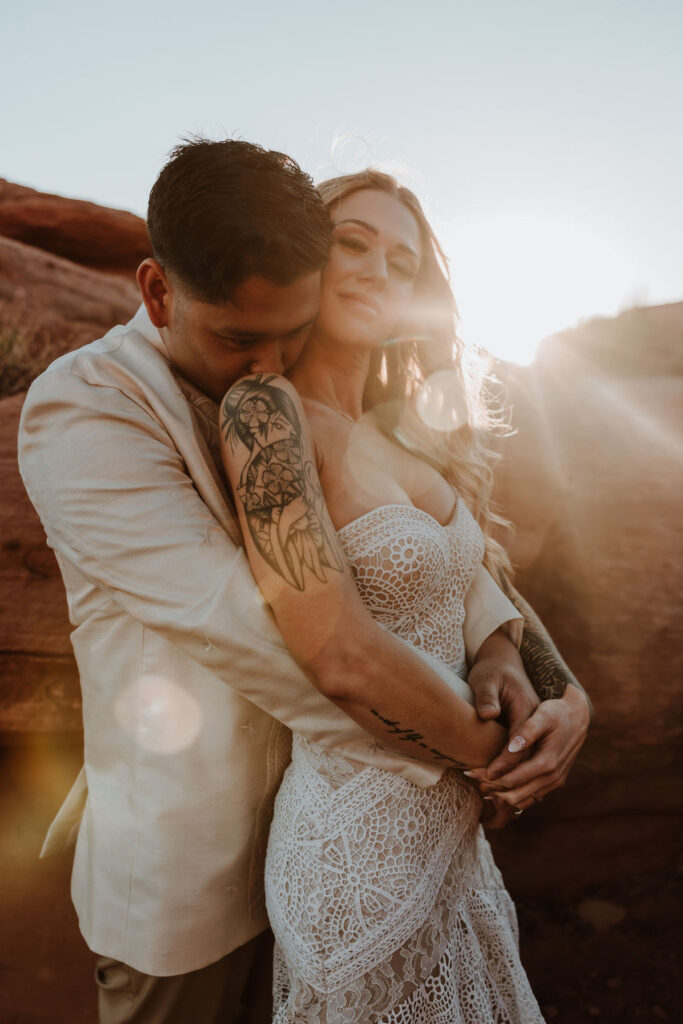 couple embrace during sunset in Moab