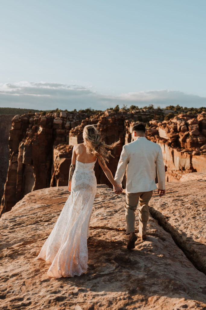 couple walk together holding hands along rocky path 