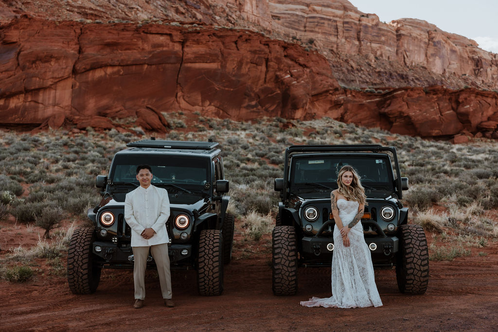 bride and groom each stand in front of a jeep