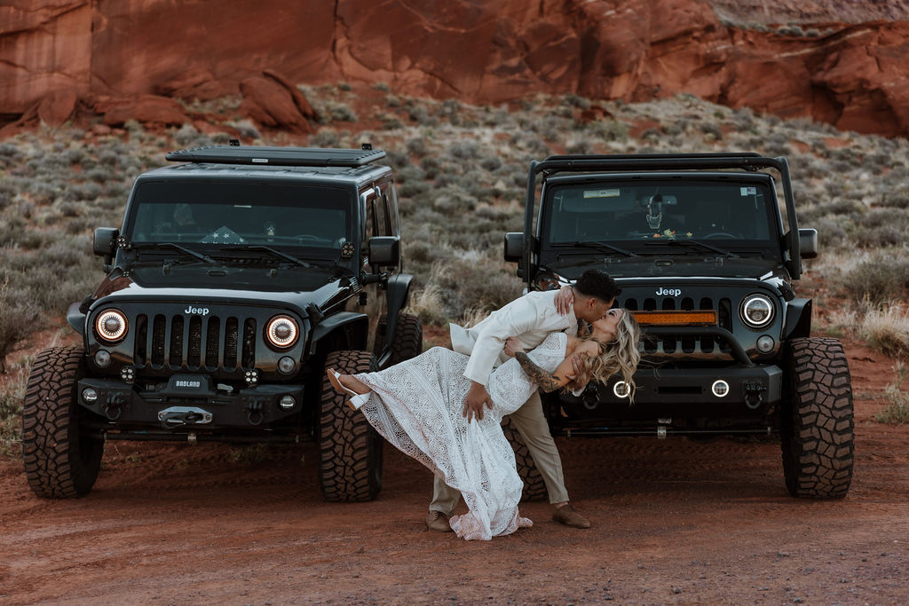 couple kissing in front jeeps 