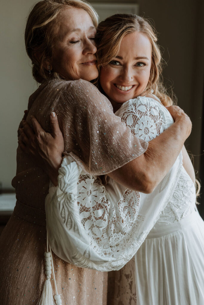 bride hugs mother while getting ready for Moab desert wedding