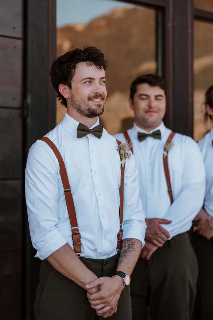 groom looking down aisle at his bride during ceremony