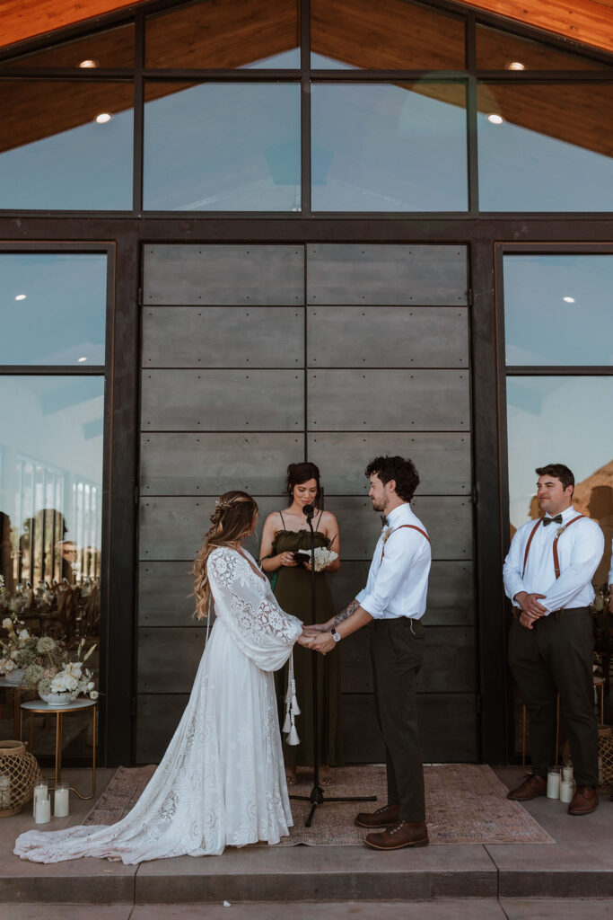 couple holding hands during Moab desert wedding ceremony