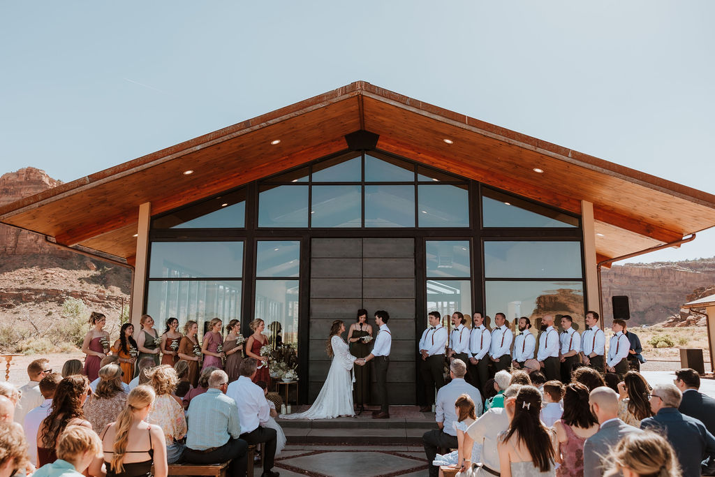 Moab desert wedding ceremony takes place in front of Red Earth venue