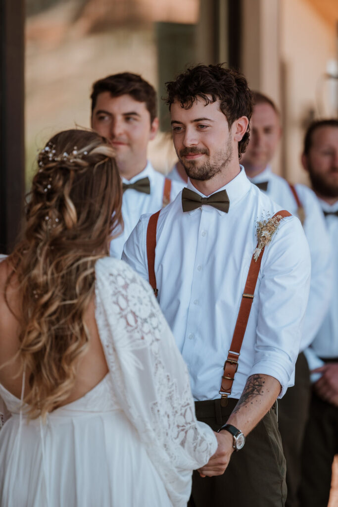 couple holding hands during Moab desert wedding ceremony