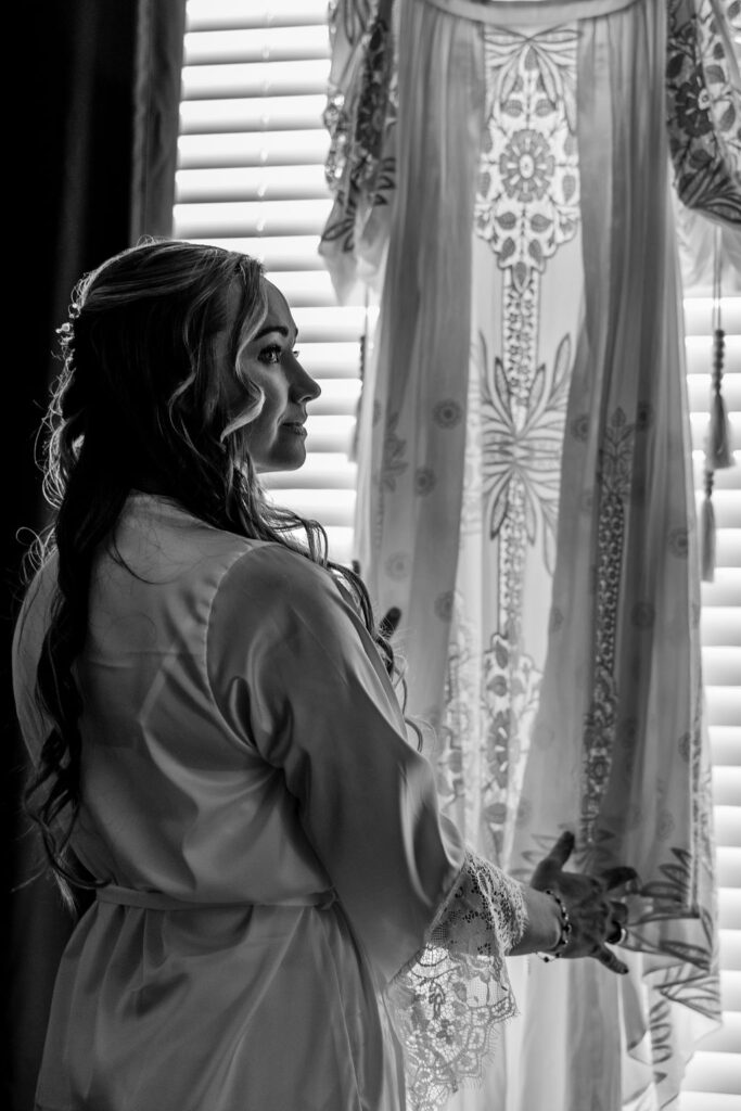 bride admiring her dress by the window