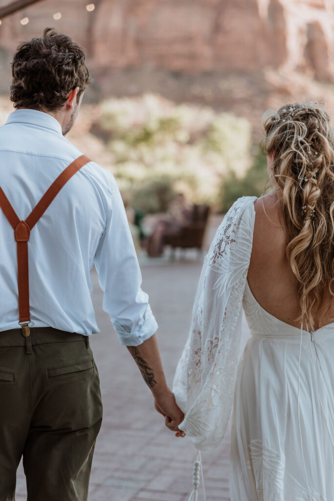 couple holding hands walking into their reception