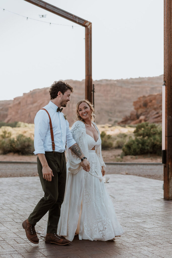 couple walking together holding hands during reception
