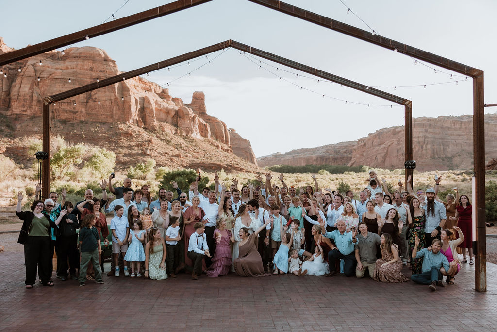 entire wedding party and all guests pose for a group shot at Red Earth venue