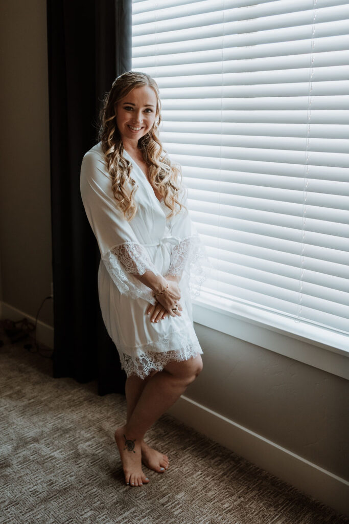 bride poses in her getting ready outfit 