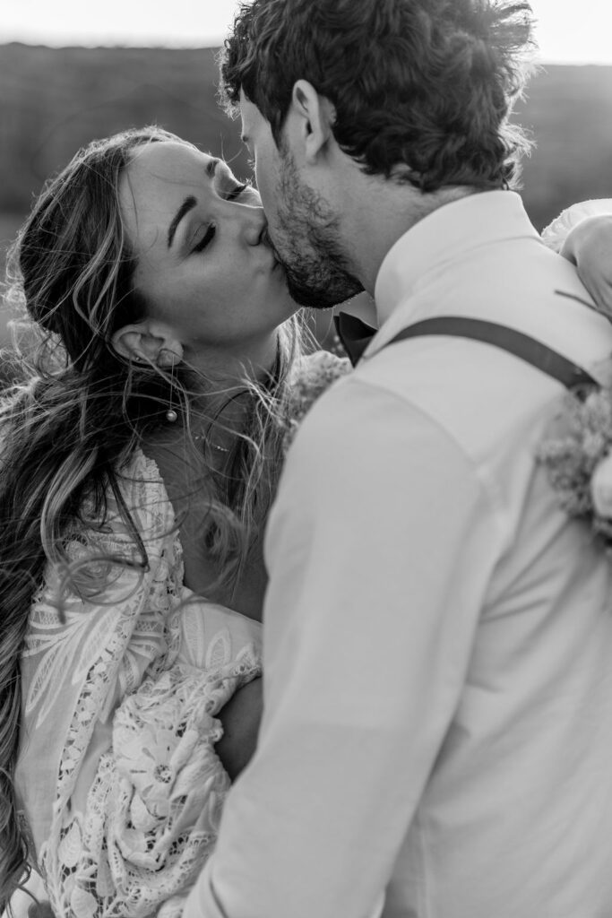 couple kisses during sunset photos in Moab desert