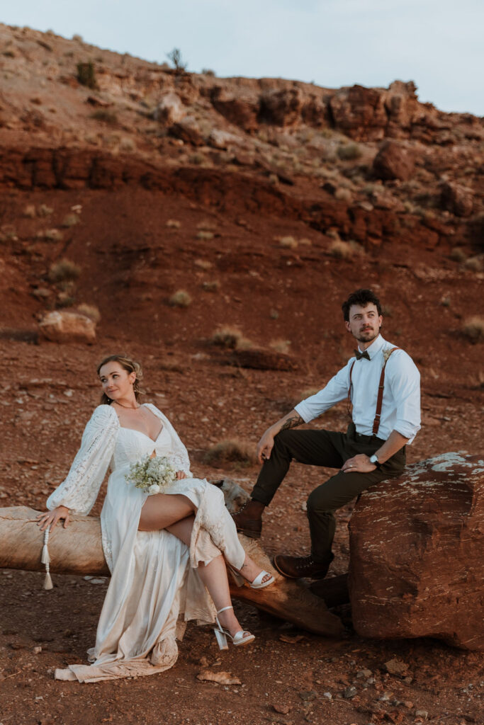 couple poses in front of rock structure of Moab desert