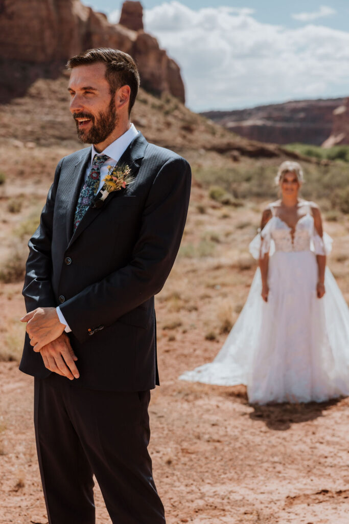 couple's first look surrounded by Moab's rocky landscape