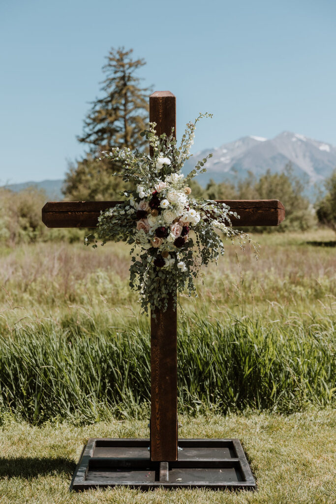 ceremony decor which includes a cross with florals