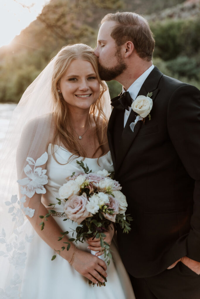 groom kissing bride on forehead