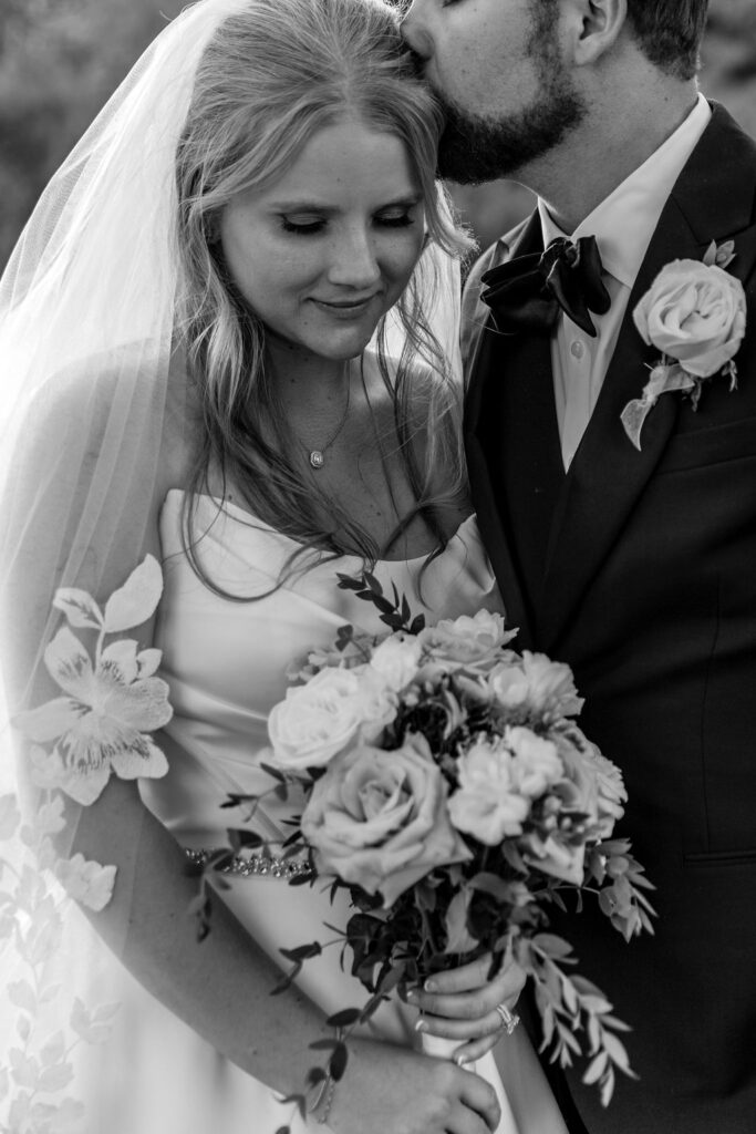 groom kissing bride on forehead