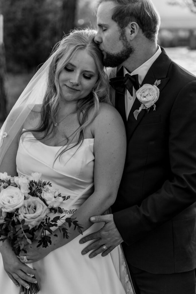 groom kissing bride on forehead
