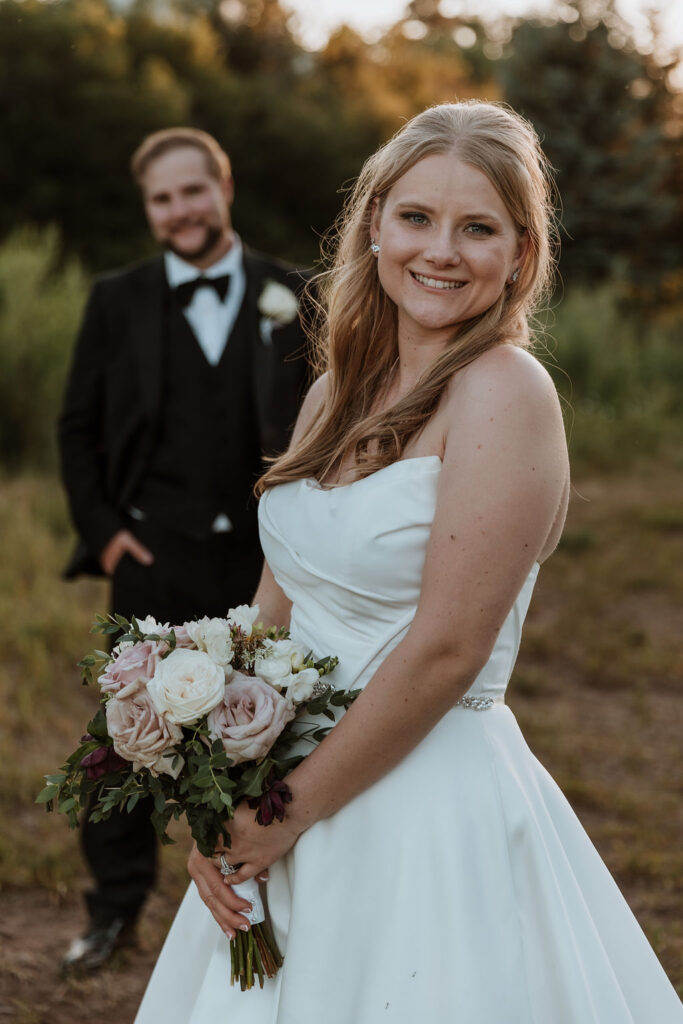 couple pose in grassy meadows of Spring Creeks Ranch