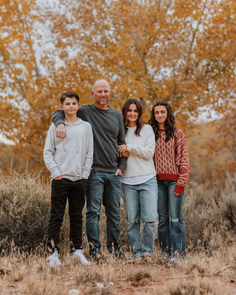 family poses together while walking along one of Moab's hiking trails