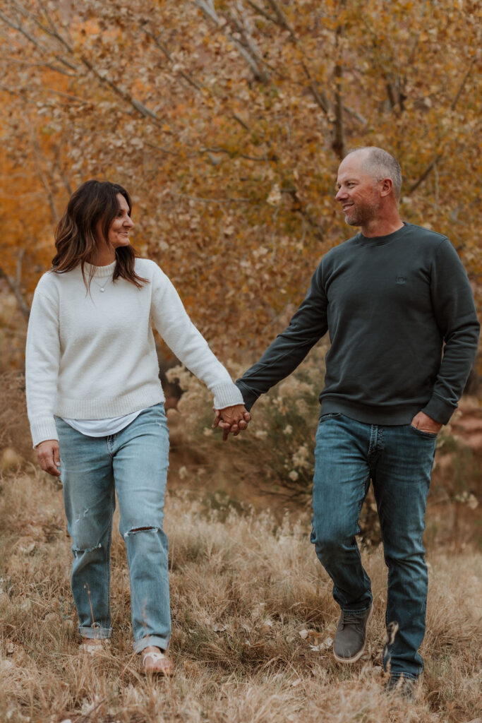 couple walks together holding hands along Moab hiking trails