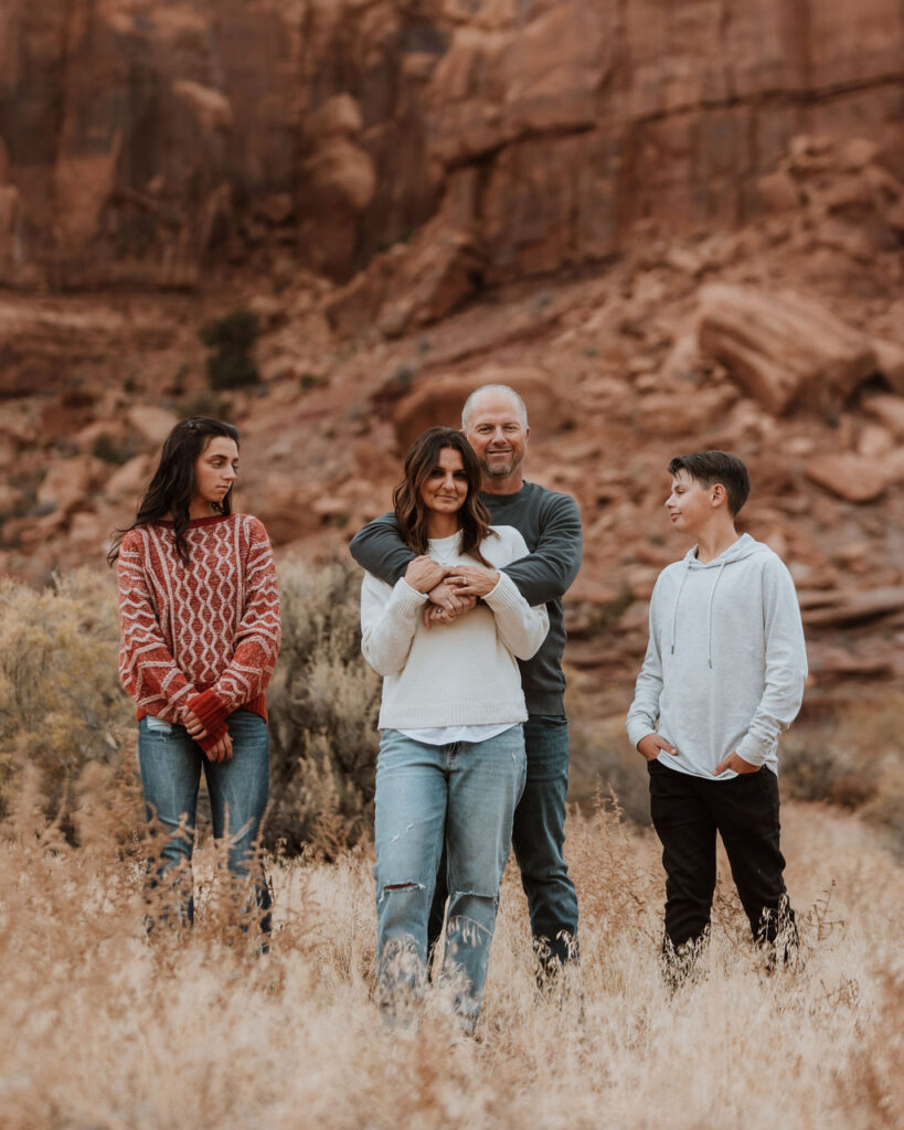 family poses together while walking along one of Moab's hiking trails