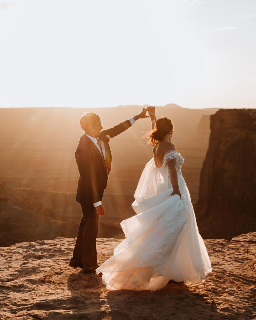 groom spins bride during sunset photos 
