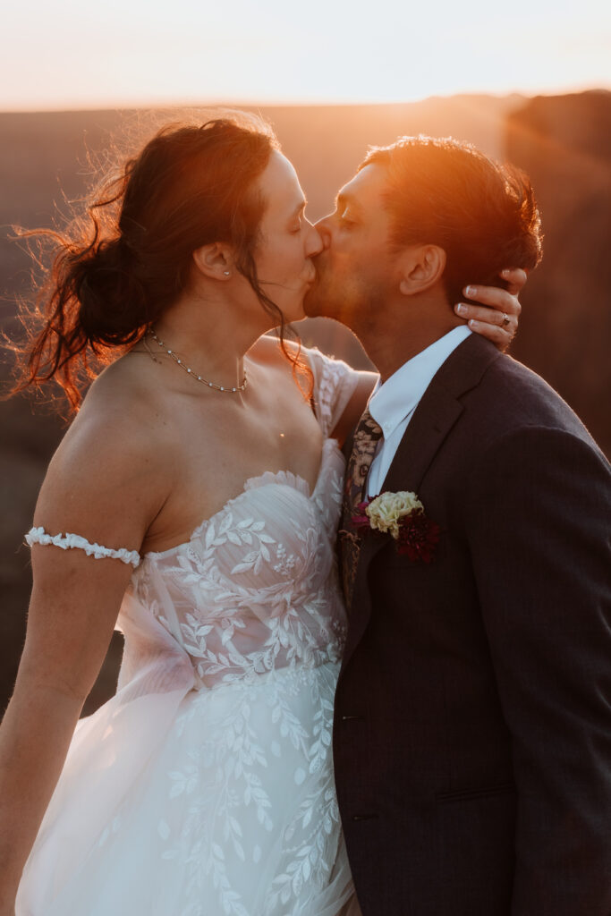 couple kiss during sunset photos in Moab