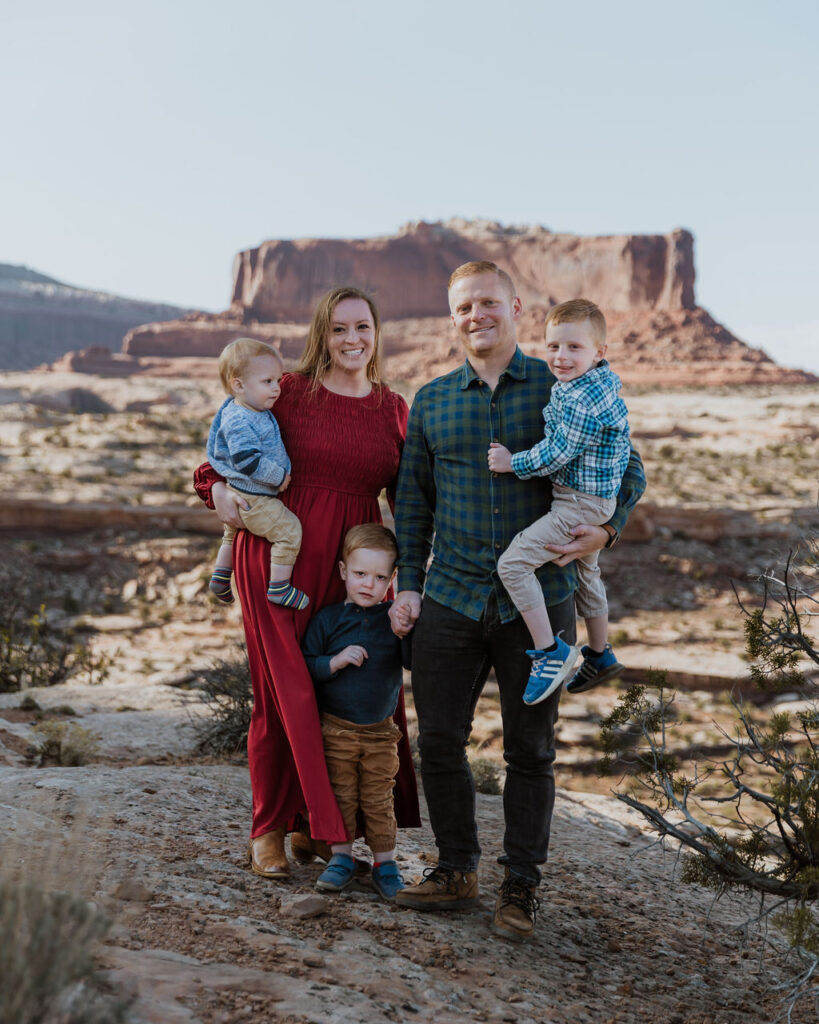 family poses together while walking along one of Moab's hiking trails