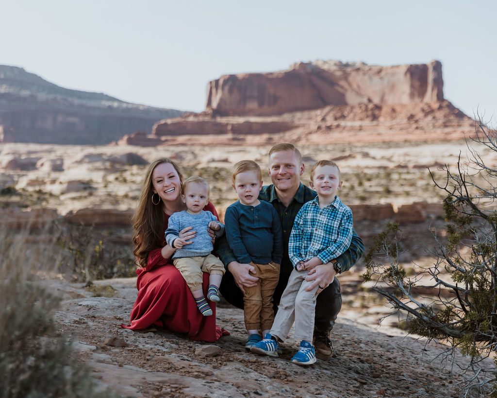 family poses together while walking along one of Moab's hiking trails