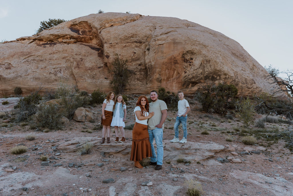 family poses together while walking along one of Moab's hiking trails