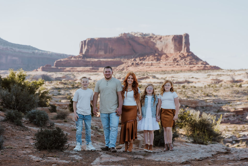 family poses together while walking along one of Moab's hiking trails