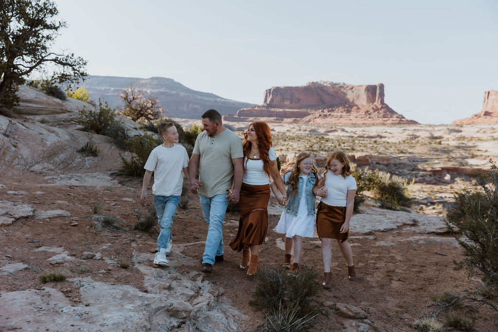 family walks together holding hands along Moab hiking trails