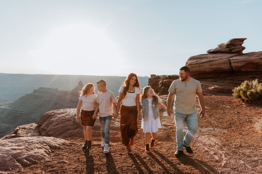 family walks together holding hands along Moab hiking trails
