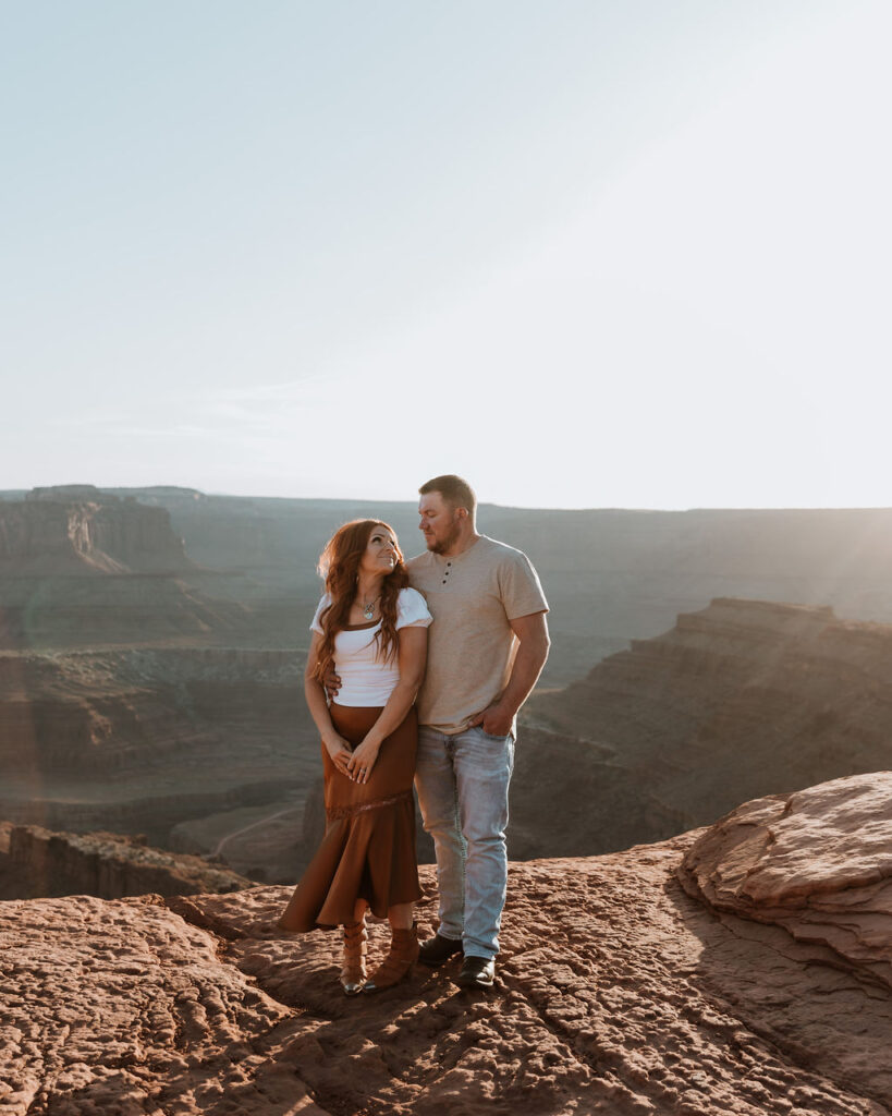 couple pose together on rocky ledge 