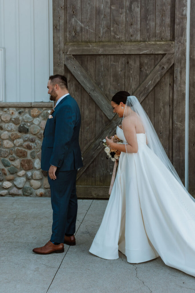 couple stand apart waiting to do their wedding first look