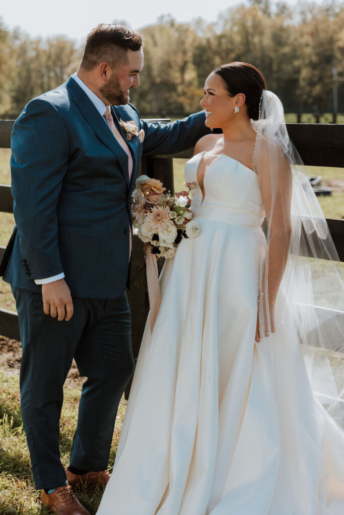 couple stand along fence after doing wedding first look