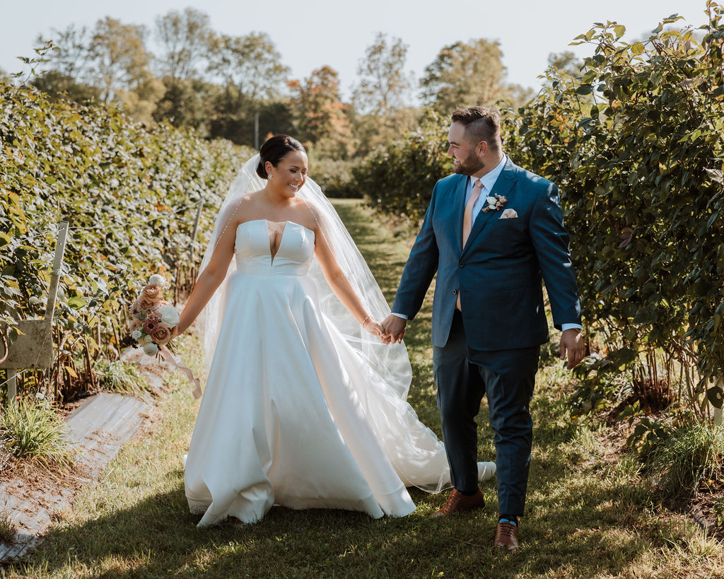 couple walks together in a path at the vineyard