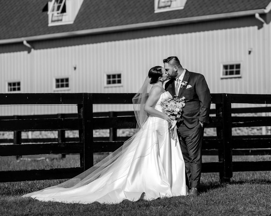 couple kiss along fence