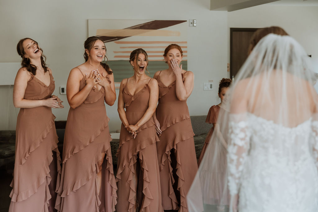 bride doing first look with bridesmaids