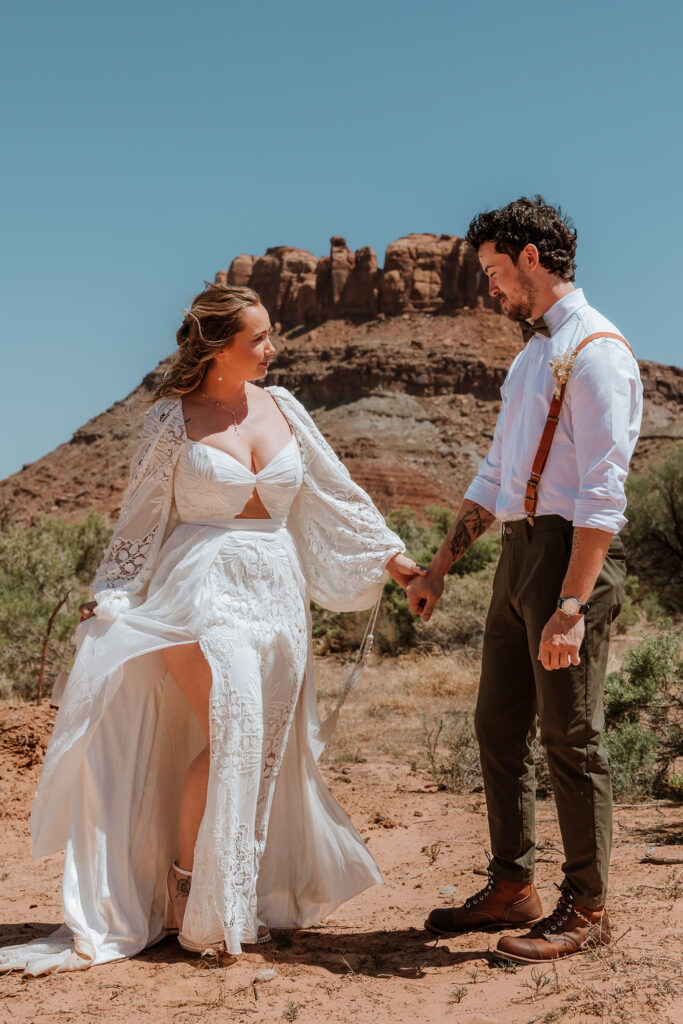 couple hold hands during wedding first look