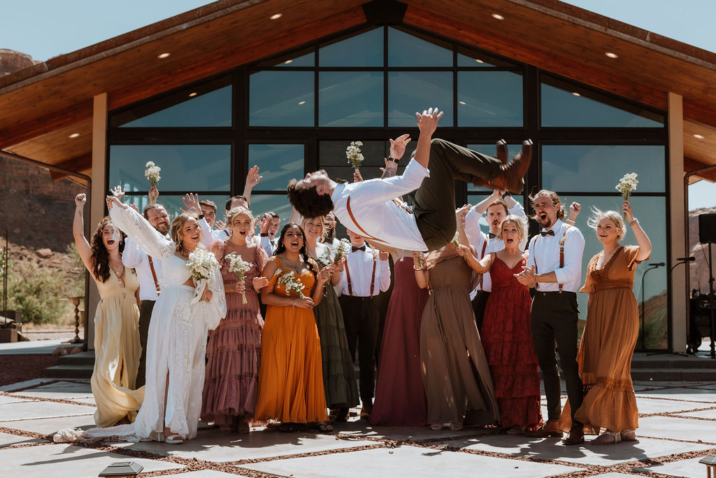 groom does a back flip in front of the wedding party
